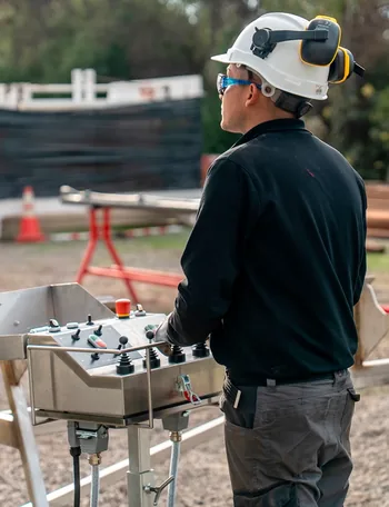 Operador de Next Drill Rigs junto a un equipo